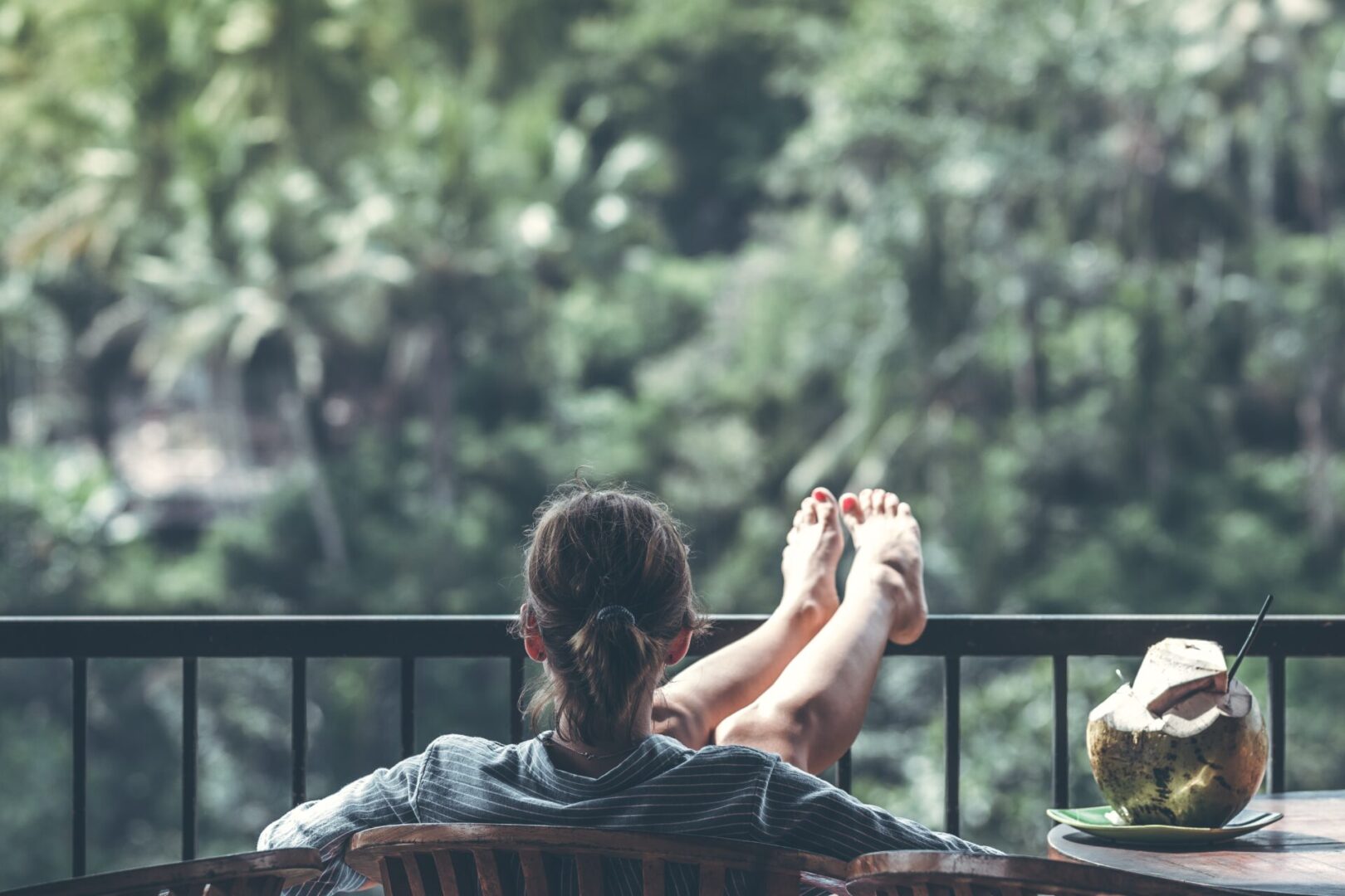 woman-sitting-on-brown-wooden-chair-beside-coconut-1230665